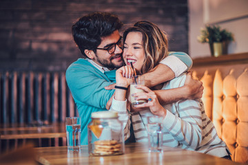  Beautiful loving couple sitting in a cafe drinking coffee and conversating. Love and romance concept.