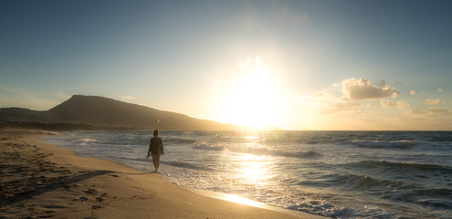 Walk of a woman on the island of Sardinia; Sunset on the Mediterranean