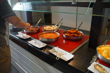 Cuisine chaude en buffet présentée dans des poêles.