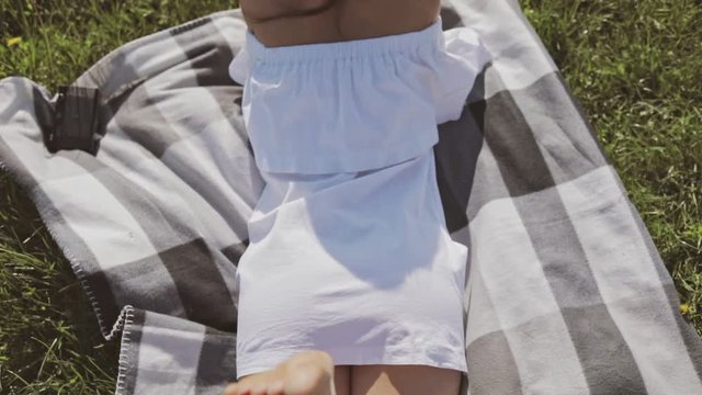 Young attractive caucasian female model reading book on meadow. Outdoor lifestyle portrait. Slow motion video shooting by handheld gimbal