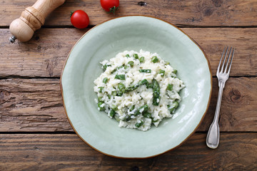 risotto con asparagi tradizionale italiano su sfondo tavolo di cucina rustico