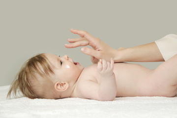 Obraz na płótnie Canvas Baby handling: Woman applying moisturizing cream on her baby's face