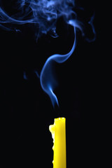 The smoke rises above the extinguished candle.