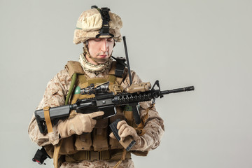 Soldier in camouflage holding rifle