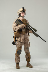 Soldier in camouflage holding rifle