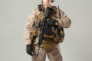 Soldier in camouflage holding rifle