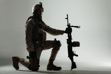 Soldier in camouflage holding rifle