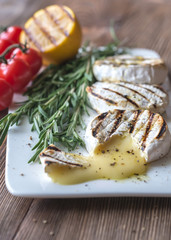 Grilled Camembert cheese with cherry tomatoes and rosemary