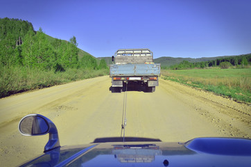 Towing a car on a country road. Breakdown of the car on the road.

