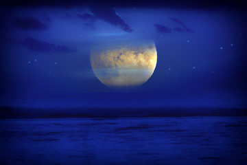 Exotic Moon and stars rising from the ocean horizon. 