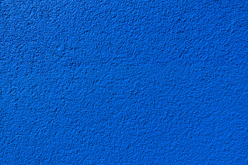 Detail einer blauen Wandstruktur aus körnigem Rauputz