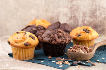 Homemade muffins with chocolate, vintage background.