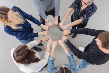 Team of diverse people make a motivational gesture