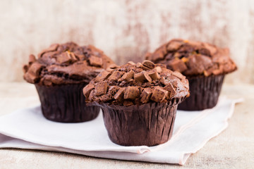 Homemade muffins with chocolate, vintage background.
