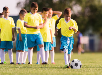 Obraz premium Boy kicking football on the sports field
