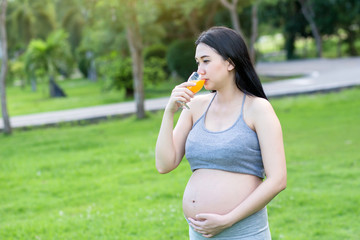 Fototapeta premium Pregnant Young Woman drinking Fresh Juice
