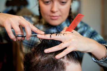 Fototapeta premium Master cuts hair and beard of men in the barbershop