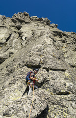 Leading a pitch through a climber in the mountains on a rocky rib.