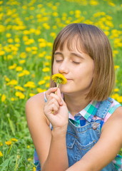 bright portrait of cute teenage girl breathing in the fragrance of flower