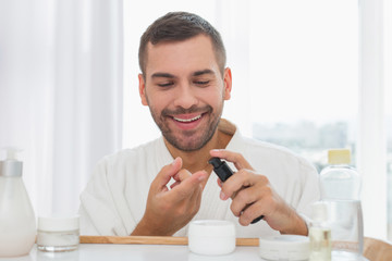 Cleaning procedure. Joyful nice man applying cleansing gel while washing his face in the morning