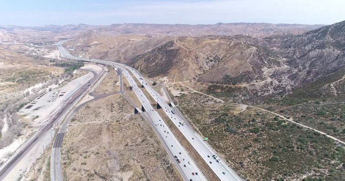 Aerial view of interstate highway traffic between mountains - August 2017: Interstate 15, California, US