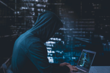 Anonymous hacker with laptop in front of binary code cyber security