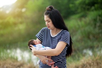 Young woman holding her sleeping baby