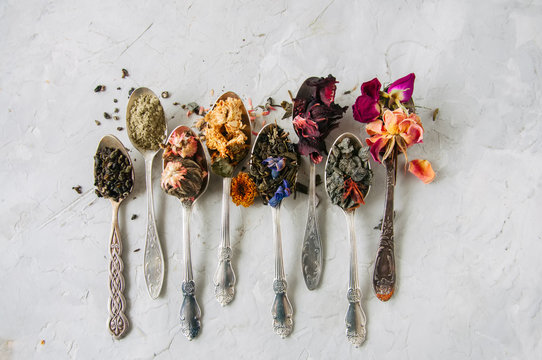 Various flavors of tea. Green tea flower tea matcha karkade in spoons. Flat lay.