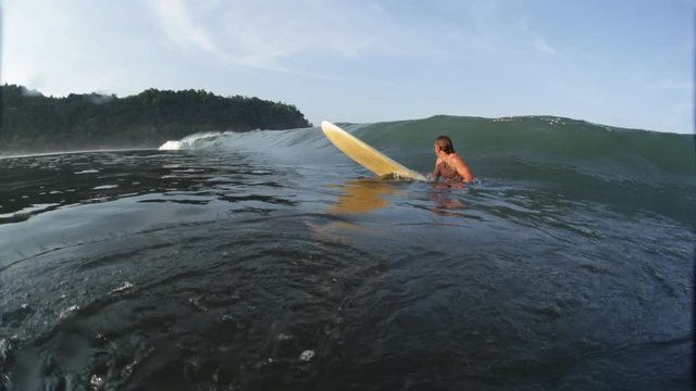 Amateur surfer makes mistake and waits the wave in a wrong place and finally gets covered by coming wave, shaky hand held camera