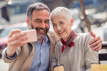 Happy mature couple taking a selfie in the city