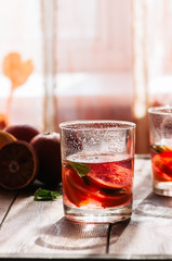 Refreshing blood orange water or infused water in a glass on a wooden background.