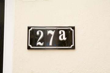 House number 27A sign on wall in ceramic tiles