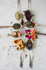 Various flavors of tea. Green tea flower tea matcha karkade in spoons. Flat lay.