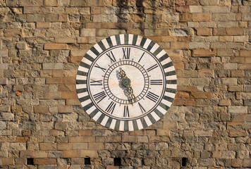 Pistoia bell tower old clock, made at the end of the 19th century on a ancient medieval wall
