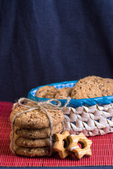 homemade oat cookies with sunflower seeds in and rear blue checkered basket on wooden table
