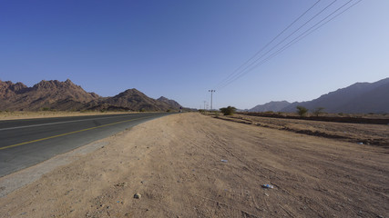 View of mountain, windy road and desert. Selective focus and crop fragment.