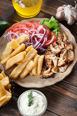 Greek gyros dish with french fries and vegetables