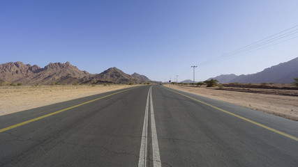 View of mountain, windy road and desert. Selective focus and crop fragment.