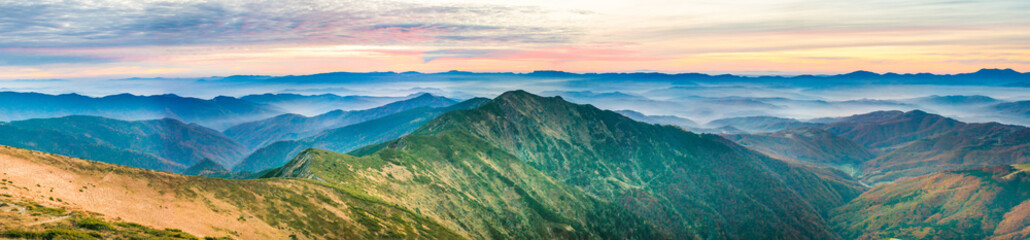 Panorama with landscape of mountains and blue hills at sunset