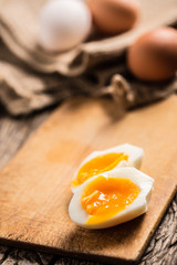 Close-up boiled or raw chicken eggs on wooden board
