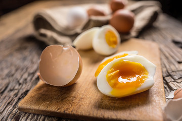 Close-up boiled or raw chicken eggs on wooden board