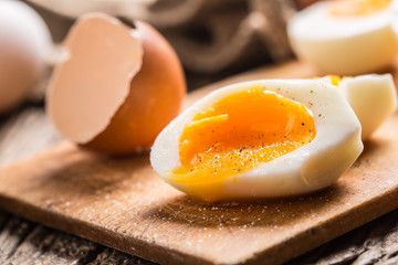 Close-up boiled or raw chicken eggs on wooden board