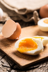 Close-up boiled or raw chicken eggs on wooden board