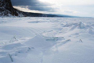 Fototapeta na wymiar Winter landscape, Crystal clear ice chunks, icicles,Lake Baikal, Siberia, Russia. Sunny winter day weather, ice cracks, clear water, slippy and cold frozen ground.Beautiful wallpaper with nature scene