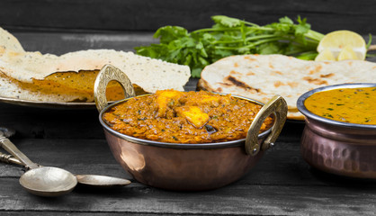 Indian Food Kadai Paneer Served With Dal Makhani, Tandoori or Papad Also Called Kadhai Paneer or Karahi Paneer is an Indian Dish of Marinated Paneer Cheese Served in Spiced Gravy on Wooden Background