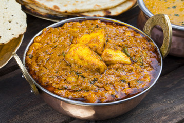 Indian Food Kadai Paneer Served With Dal Makhani, Tandoori or Papad Also Called Kadhai Paneer or Karahi Paneer is an Indian Dish of Marinated Paneer Cheese Served in Spiced Gravy on Wooden Background
