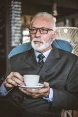 Portrait of senior businessmen at coffee break.