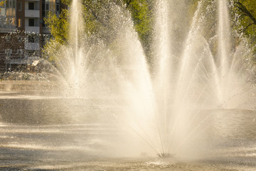Spray from the fountain in the city as a background