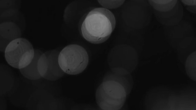 Abstract blurry black and white bokeh spots in motion