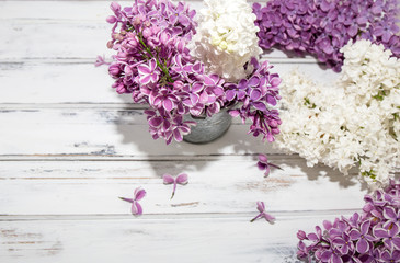 Flowers of lilac.White old background with space for text.Purple color.lilac in a small bucket